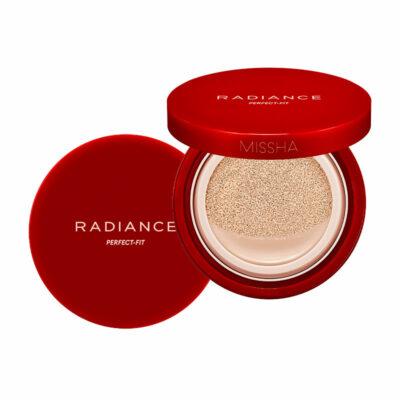 Red compact cushion foundation with open lid showing beige cushion soaked in foundation for radiant coverage