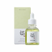 Small frosted glass dropper bottle with light green serum and minimalistic label beside pale green and white box packaging