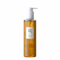 Tall amber cleansing oil bottle with white pump dispenser and minimal Korean label on white background