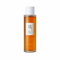 Tall cylindrical amber bottle of ginseng essence water with white label and cap for hydration boost