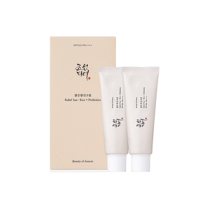 Two white tubes of sunscreen with Korean text next to beige minimalist box labeled for UV protection and skincare benefits