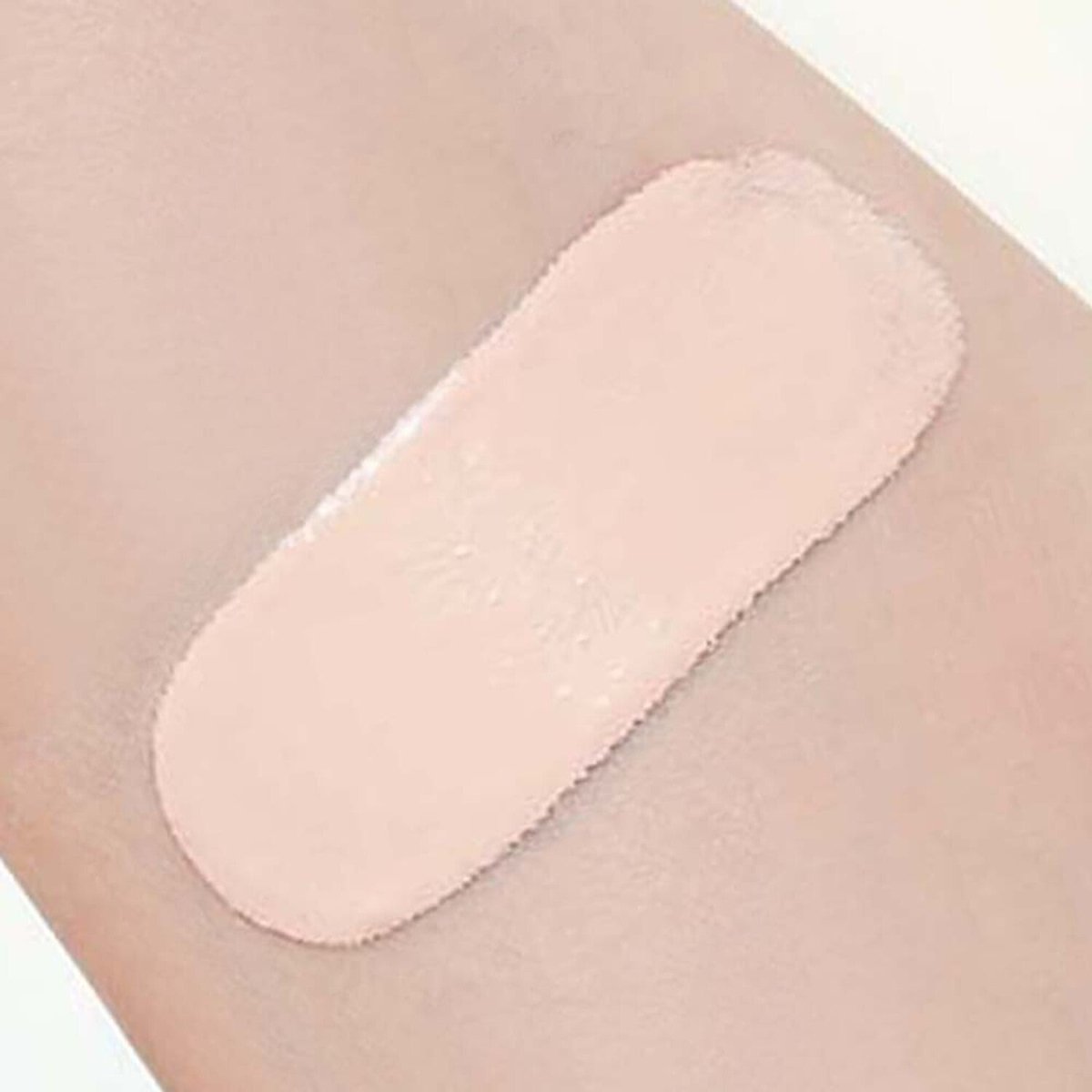 Swatch of smooth, light beige powder cushion applied on skin showcasing soft matte coverage effect
