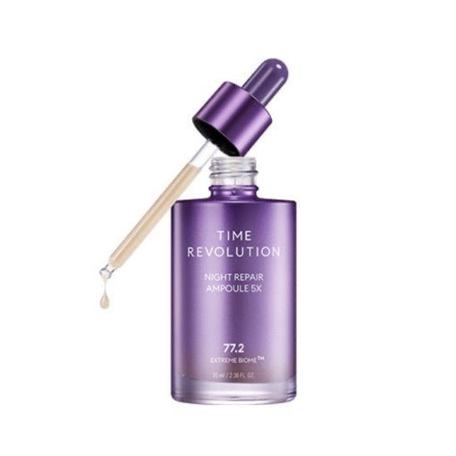 Purple glass dropper bottle of night repair ampoule with a droplet suspended from the applicator on white background