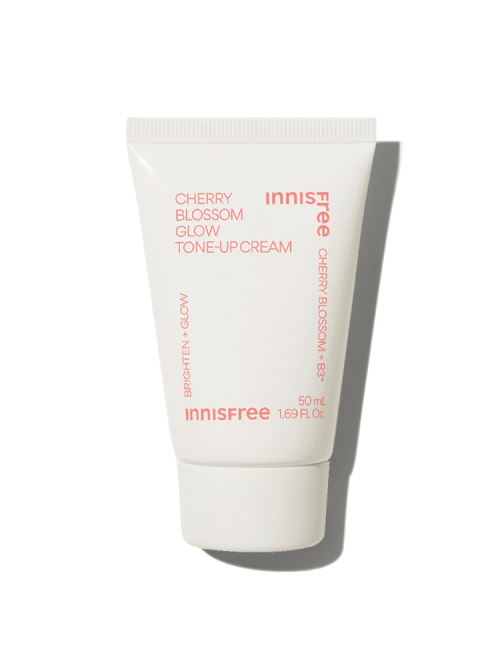 Small white tube of brightening tone-up cream with soft pink text highlighting cherry blossom and glow benefits