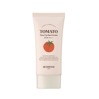 Tube of light beige sun cream with tomato illustration, highlighting SPF50+ UV protection formula for skin tone brightening