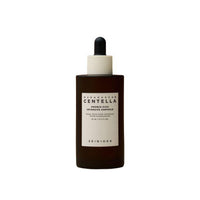 Brown glass dropper bottle with minimalist white label for calming skincare ampoule on white background