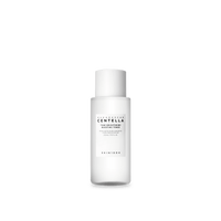 Minimalist white cylindrical skincare toner bottle with black text highlighting hydration and brightening benefits on white background