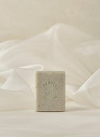 Rectangular light beige cleansing bar with speckles and embossed "Beauty of Joseon" text on soft cream fabric background