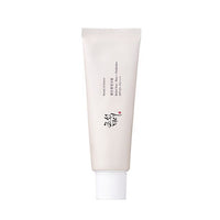 Minimalist white tube of sun protection cream featuring rice and probiotics for effective UV defense on plain background