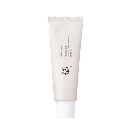 Minimalist white tube of sun protection cream featuring rice and probiotics for effective UV defense on plain background