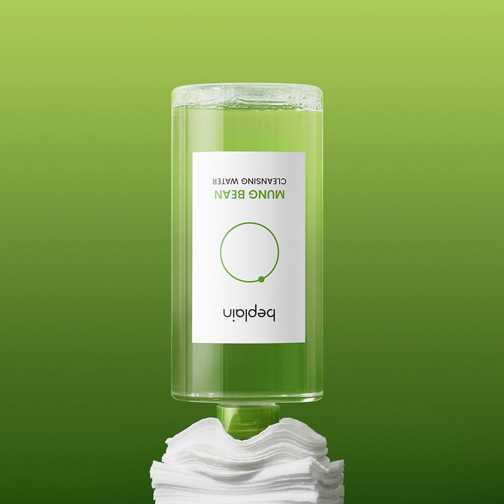 beplain Mung Bean Cleansing Water 400ml bottle inverted dispensing clear cleansing water onto cotton pads on green background