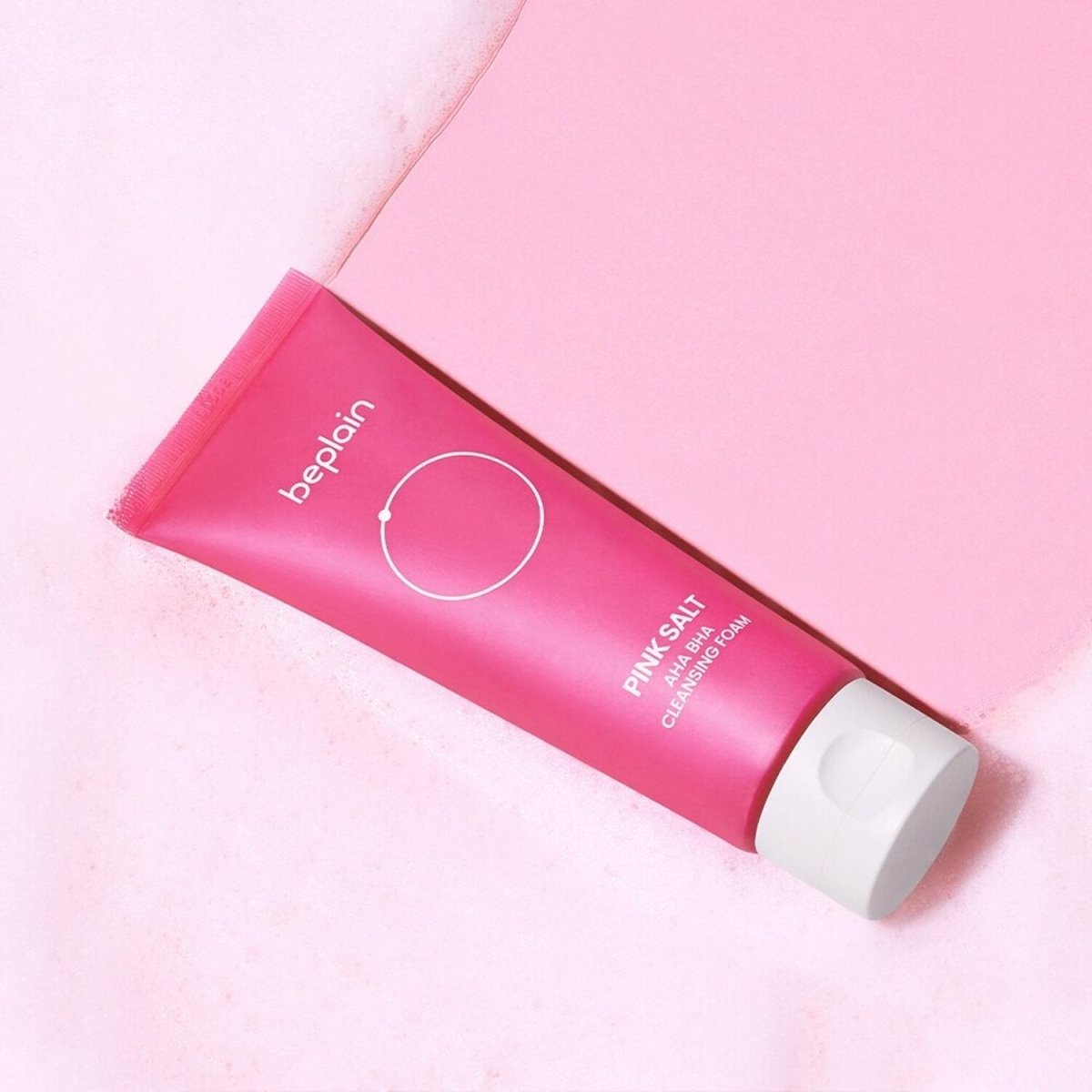 beplain Pink Salt AHA BHA Cleansing Foam 120ml in pink tube with white cap on soft foamy surface for exfoliation care