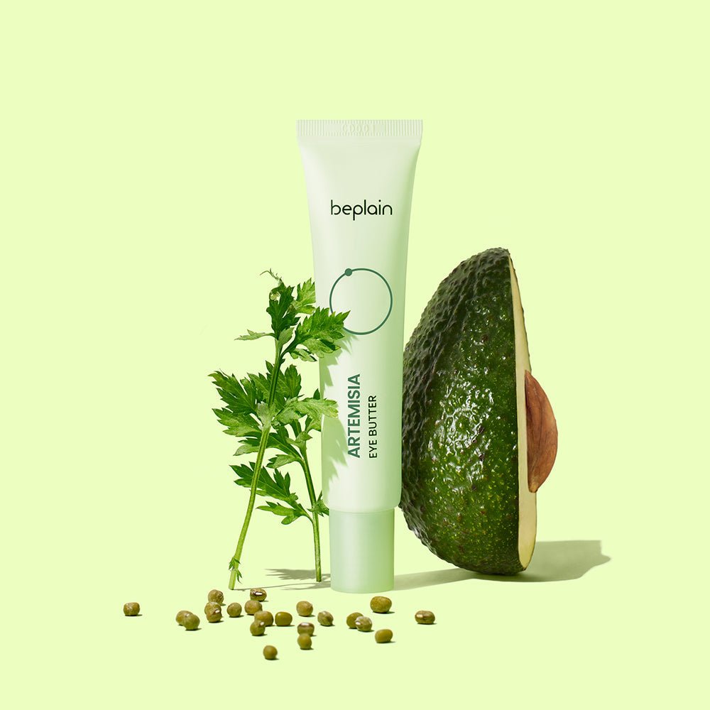 beplain Artemisia Eye Butter 25ml tube alongside fresh artemisia leaves and halved avocado for deep hydration benefits