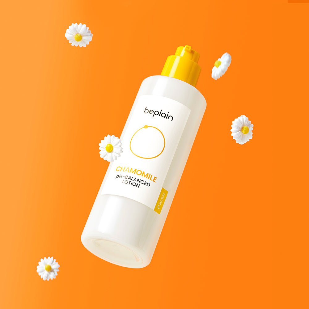 beplain Chamomile pH-Balanced Lotion 150ml bottle with yellow pump surrounded by chamomile flowers on orange background