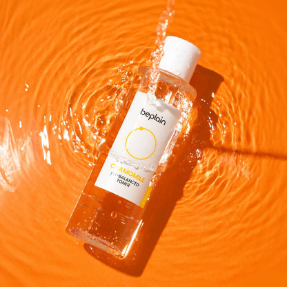 beplain Chamomile pH-Balanced Toner 200ml bottle with water splash on vibrant orange surface highlighting soothing care benefits