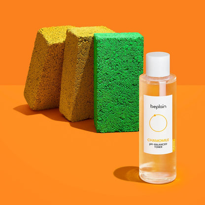 beplain Chamomile pH-Balanced Toner 200ml bottle on bright orange surface with textured yellow and green blocks behind