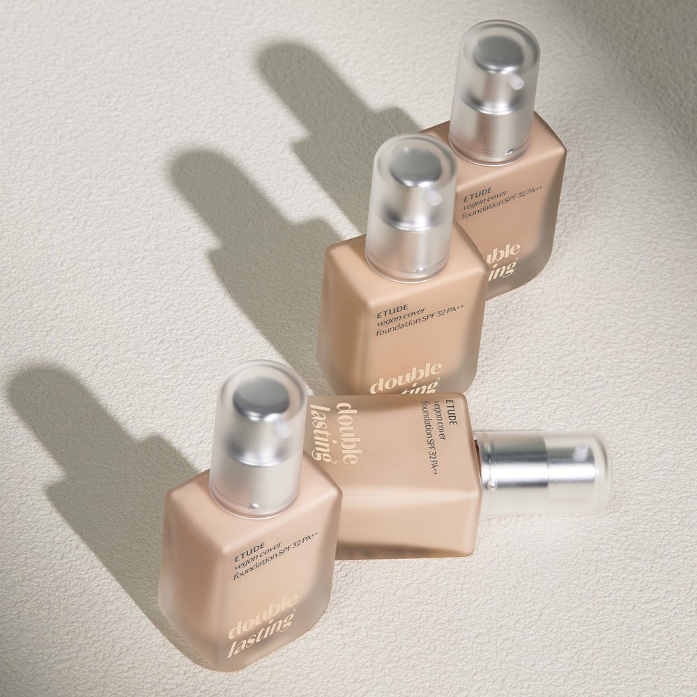 ETUDE Double Lasting Vegan Cover Foundation SPF32/PA++ 30g bottles arranged with soft shadows on textured surface