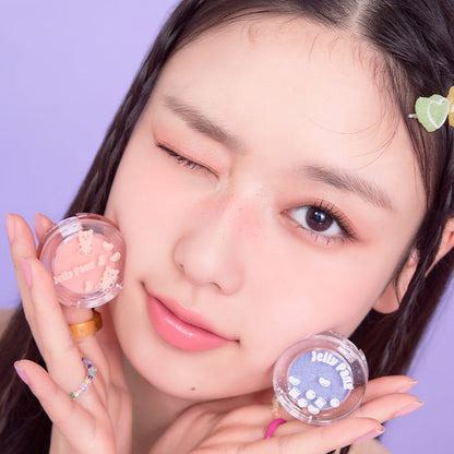 Young woman with soft makeup holding ETUDE Jelly Pang Look At My Eyes eyeshadows in pink and lavender shades