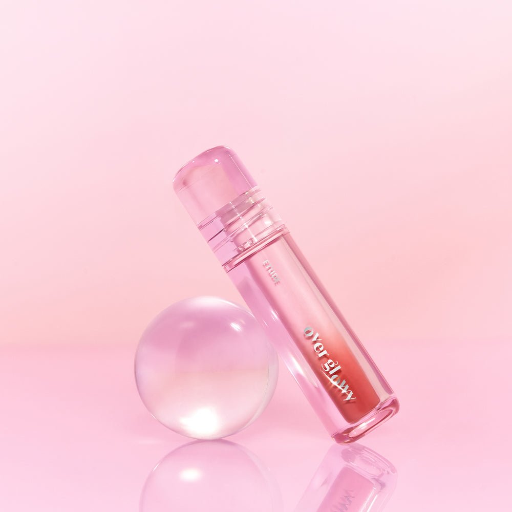 ETUDE Over Glowy Tint 3g in translucent pink tube with high gloss effect against soft pink background