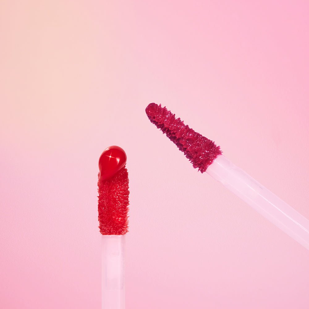 ETUDE Over Glowy Tint 3g showing two applicators with high gloss red and pink tint on a soft pink background