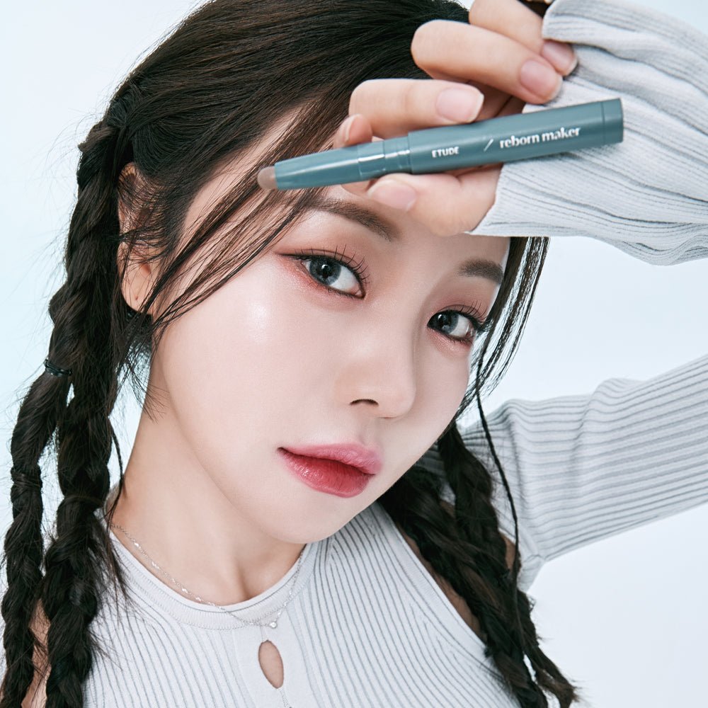 Woman with braided hair holding ETUDE Reborn Maker Contour Stick 1g in teal packaging showcasing convenient size