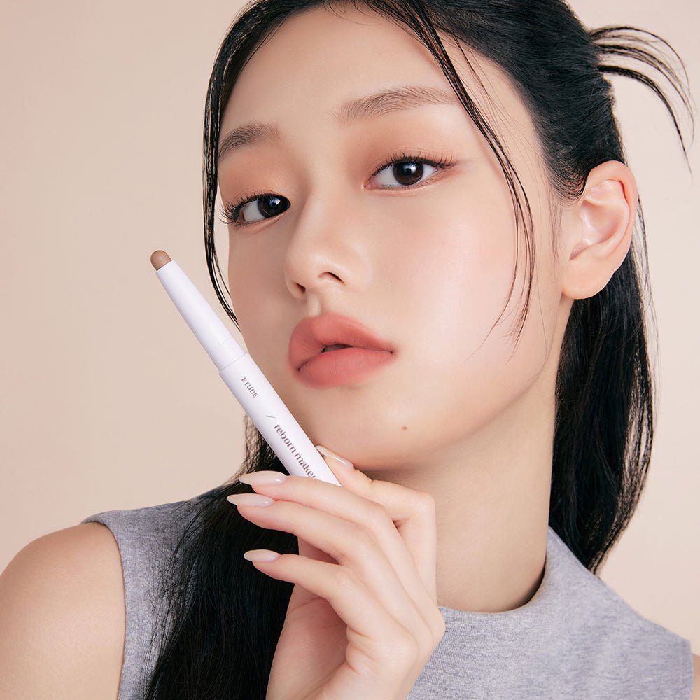 ETUDE Reborn Maker Over Lip 1g in light beige slim stick held by model with natural makeup and smooth skin