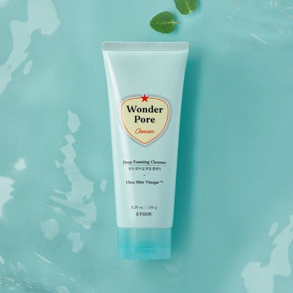 ETUDE Wonder Pore Deep Foaming Cleanser 150g tube on blue surface with mint leaves for deep cleansing