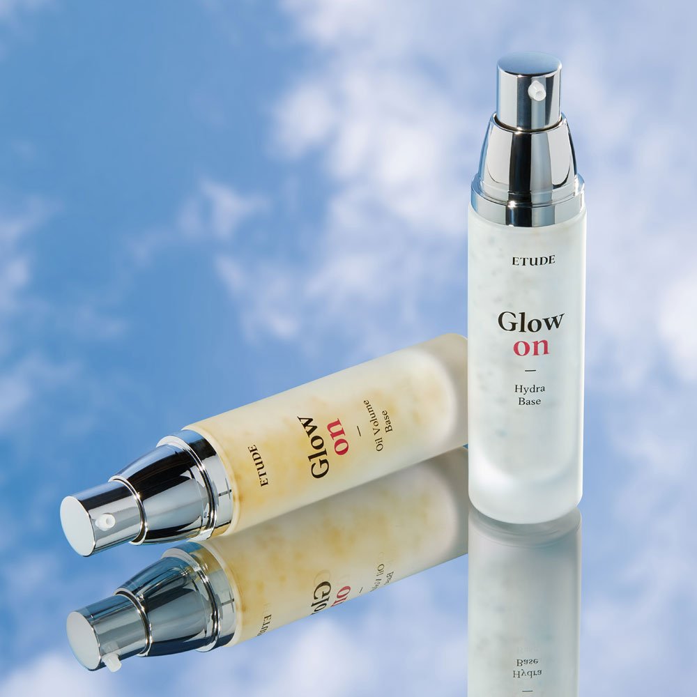 ETUDE Glow On Base Oil Volume 30ml bottle with pump dispenser on reflective surface enhancing moisture boost effect