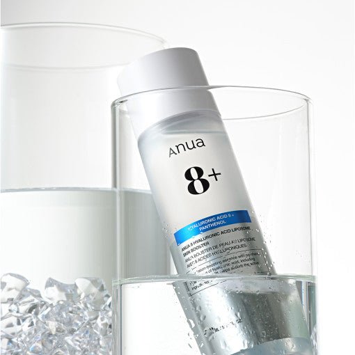 Clear bottle of hydrating skin booster with hyaluronic acid and panthenol partially submerged in water with ice cubes nearby