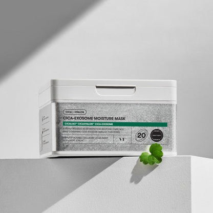 White container of VT Cica-Exosome Moisture Mask 350g 20ea with green leaf and soft natural lighting