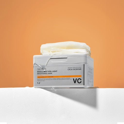 VT Reedle Shot Vita-light Brightening Mask 30ea (330g) container with stack of white sheet masks on top against orange background
