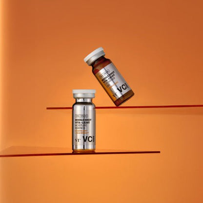 Two small clear glass vials labeled VT Reedle Shot Vita-Light Toning Essence VC 1000 1g+9ml on orange background