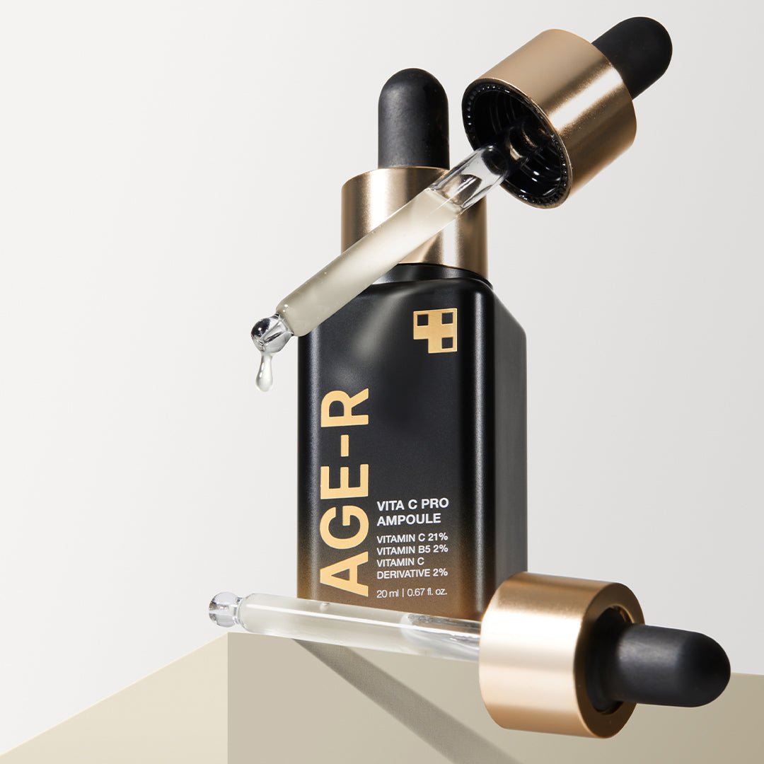 medicube AGE-R Vita C Pro Ampoule 20ml black bottle with gold accents and dropper releasing serum for brightening effect