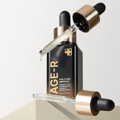 medicube AGE-R Vita C Pro Ampoule 20ml black bottle with gold accents and dropper releasing serum for brightening effect