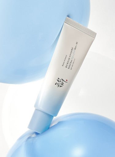 Tube of hydrating sun cream with SPF 50+ and soothing aqua-fresh formula on a glossy blue abstract background