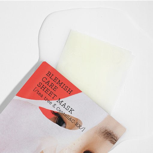 Partially unfolded blemish care sheet mask with light serum pooling on a white background highlighting soothing effect