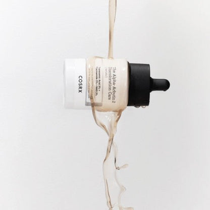Dropper bottle of brightening serum with liquid pouring over, highlighting discoloration care benefits