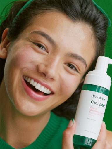 Dr.Jart+ Cicapair Gentle Cleansing Foam 150ml in white and green bottle held by smiling woman in green sweater