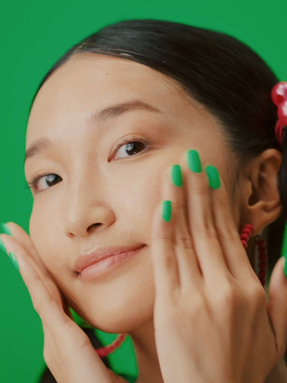 Woman gently applying Dr.Jart+ Cicapair Intensive Soothing Repair Milky Lotion 100ml on her smooth skin with green nails