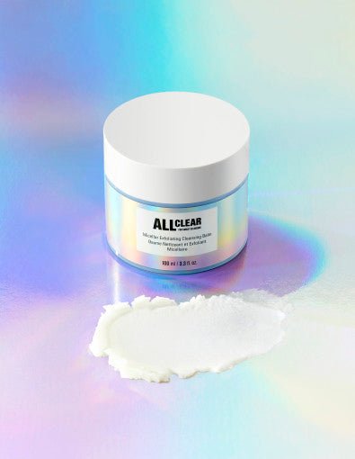 Jar of gentle exfoliating cleansing balm with white lid and creamy texture on iridescent surface