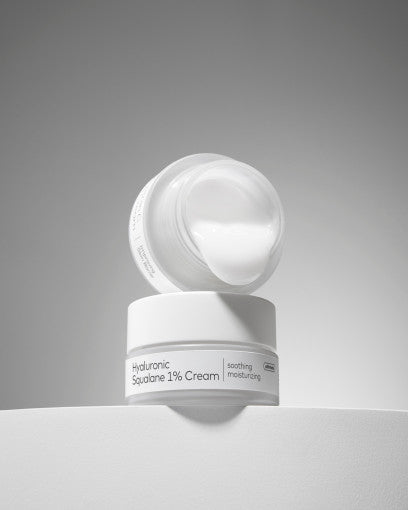 Open jar of white moisturizing cream labeled soothing formula with smooth texture on clean light surface