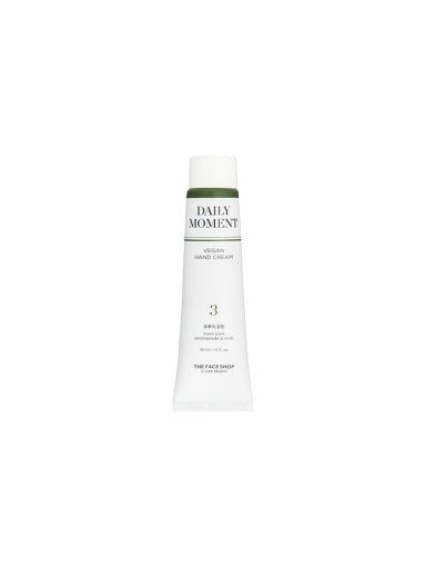 Slim white tube of Daily Moment vegan hand cream with green cap and minimalist label on white background