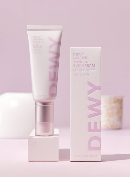 Light pink tube and box of tone-up sun cream with SPF50+ PA+++ on soft pink background with subtle decorative objects