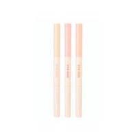 Three slim under-eye makeup sticks in soft beige, pink, and peach tones with subtle brand text on white background