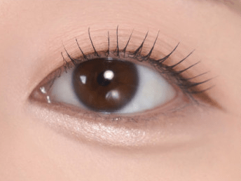 Close-up of brown eye with smooth, radiant under-eye area showcasing subtle highlighting effect from precision application product.