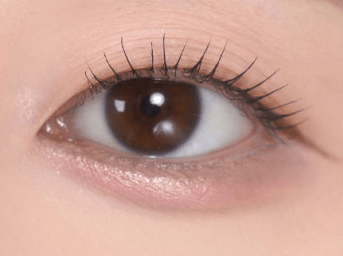 Close-up of eye with natural-looking under eye makeup highlighting smooth, precise application for brightening and lifting effect