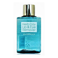 Transparent blue bottle of gentle waterproof lip and eye makeup remover with silver cap on white background