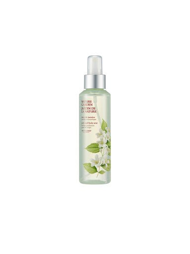 Transparent spray bottle of floral-scented body mist with delicate white flower design on label
