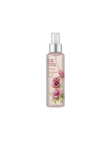 Transparent bottle of perfumed body mist with pink floral design and silver spray cap on white background