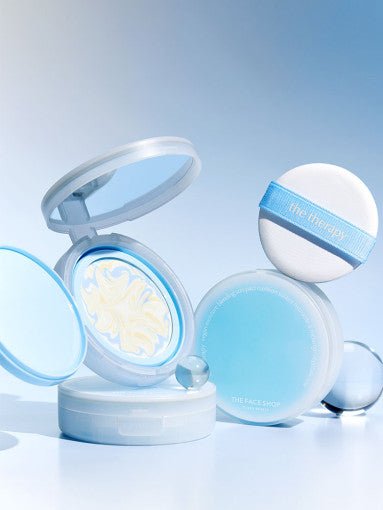Open blue compact with swirled moisturizing sun pact cream and white puff with blue strap on reflective surface